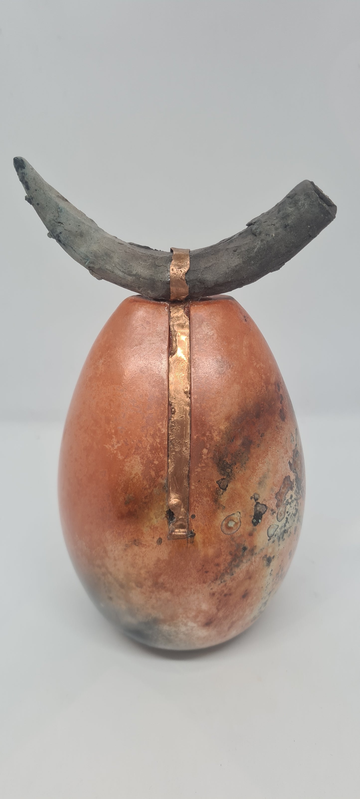 Orange and black horned totem with copper strip