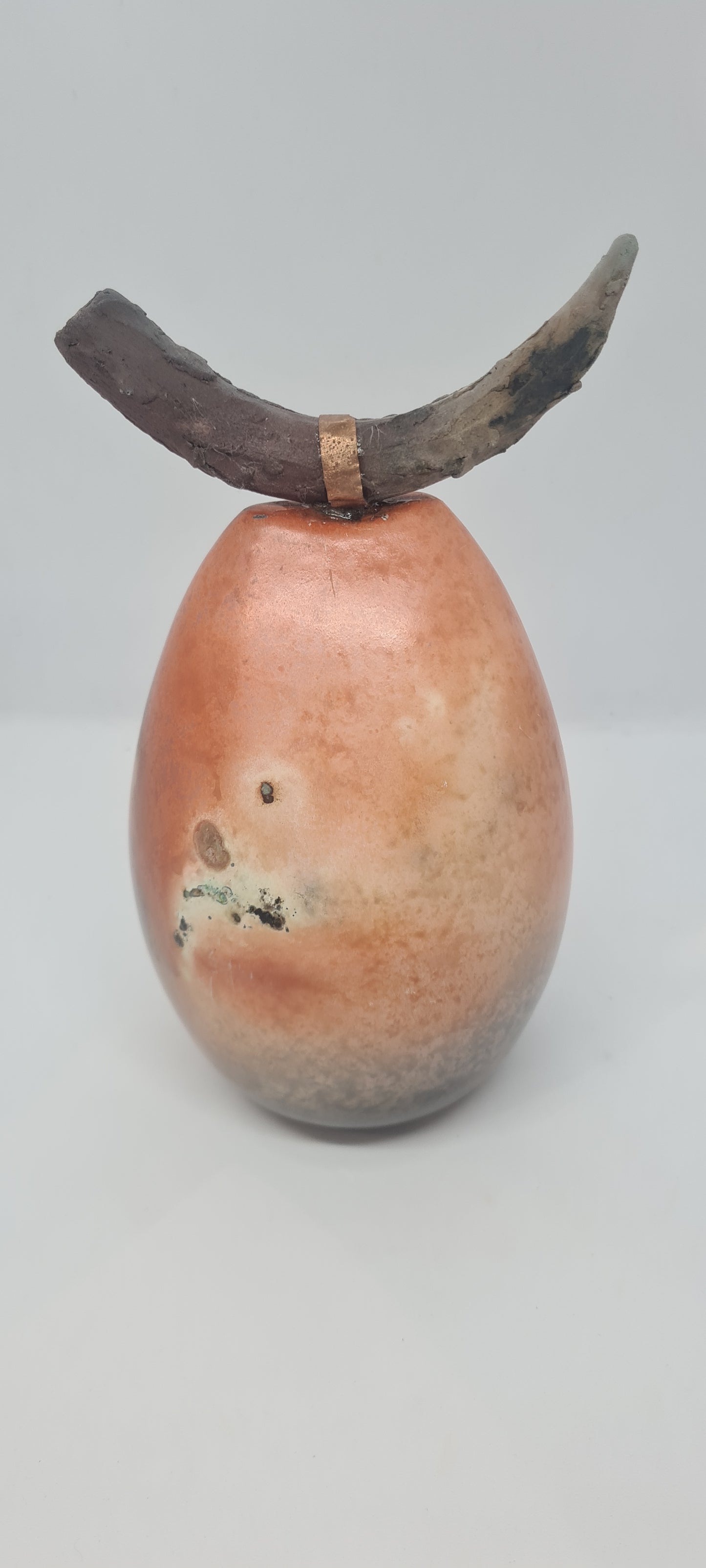 Orange and black horned totem with copper strip